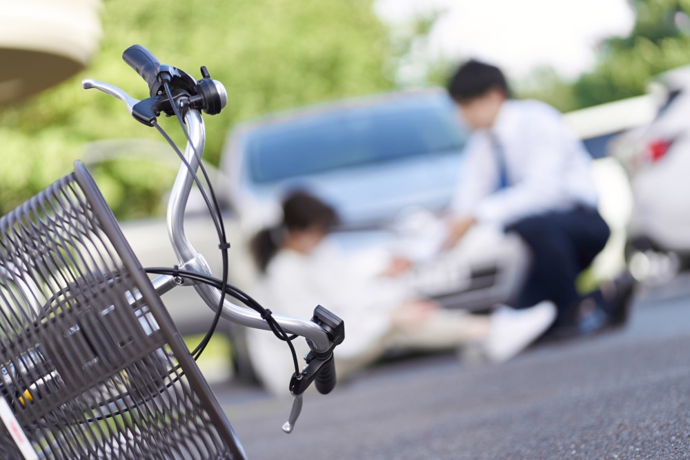 Bicycle accident scene in Indianapolis showing injured cyclist near car, representing personal injury claim and medical lien case